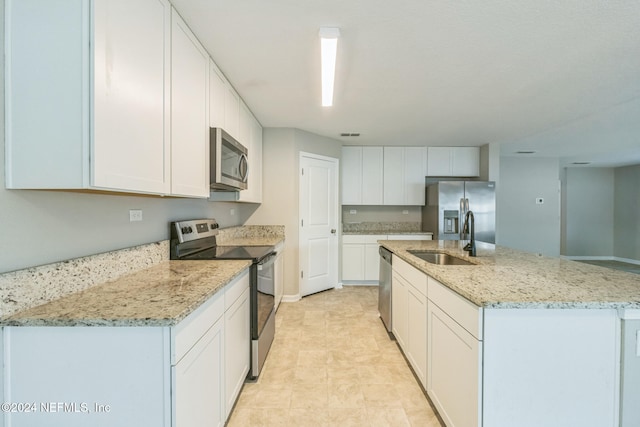 kitchen featuring a kitchen island with sink, white cabinetry, sink, and stainless steel appliances