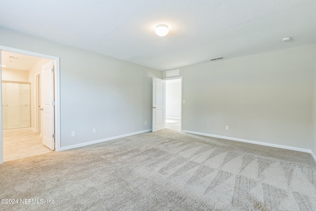 carpeted spare room featuring a textured ceiling