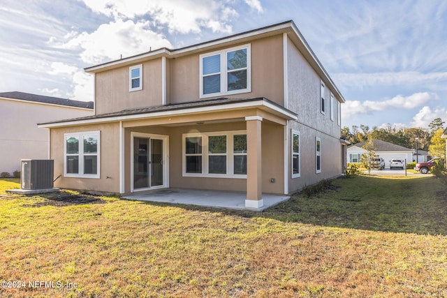 rear view of house with central AC, a patio area, and a lawn