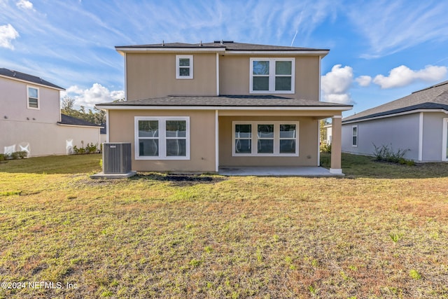 back of property featuring a lawn, cooling unit, and a patio