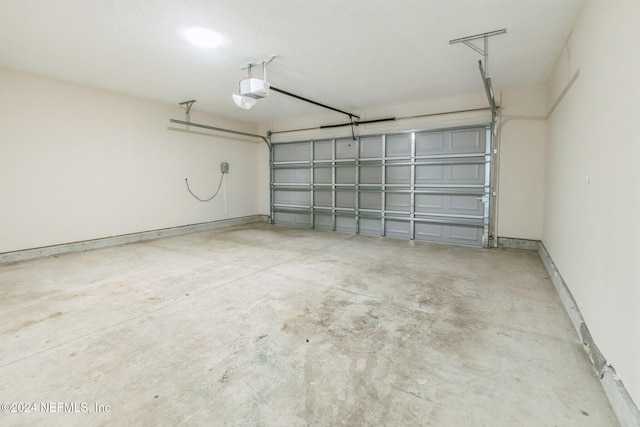 garage with a garage door opener and baseboards