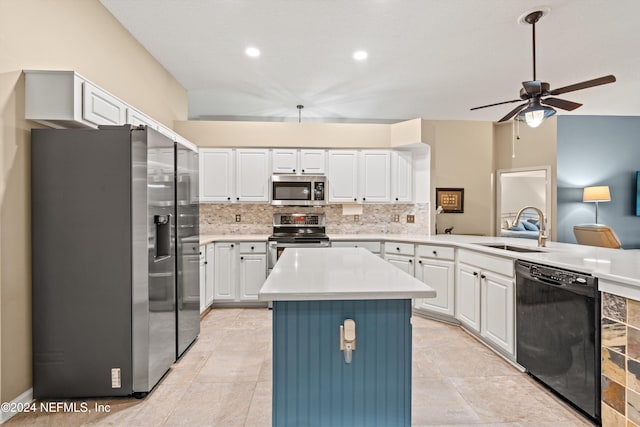 kitchen with white cabinets, appliances with stainless steel finishes, sink, and a kitchen island