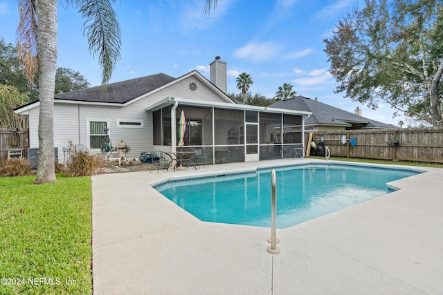 view of swimming pool with a yard, a sunroom, and a patio area