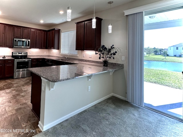 kitchen with a breakfast bar area, hanging light fixtures, stainless steel appliances, a healthy amount of sunlight, and kitchen peninsula