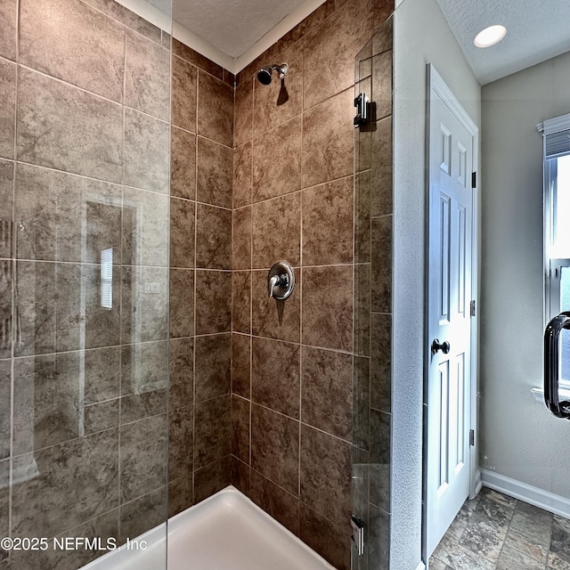 bathroom with tiled shower and a textured ceiling