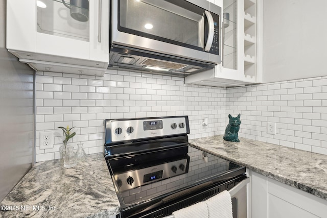 kitchen with white cabinets, decorative backsplash, and appliances with stainless steel finishes