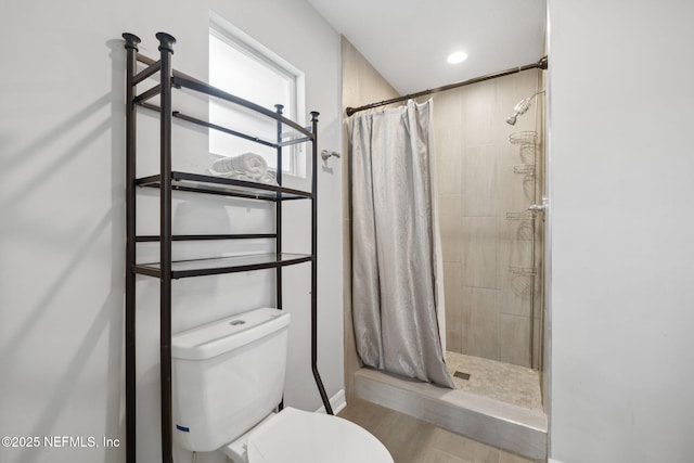 bathroom featuring a shower with shower curtain, toilet, and hardwood / wood-style flooring