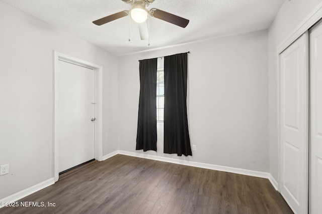 unfurnished bedroom featuring a textured ceiling, dark hardwood / wood-style flooring, a closet, and ceiling fan