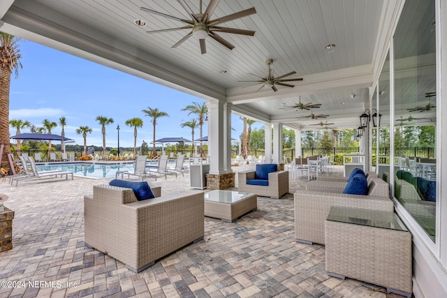 view of patio with ceiling fan, a community pool, and an outdoor hangout area