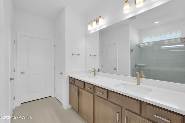 bathroom featuring double vanity, a stall shower, a sink, and visible vents