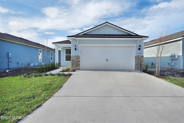 view of front of property with concrete driveway, board and batten siding, a garage, stone siding, and a front lawn