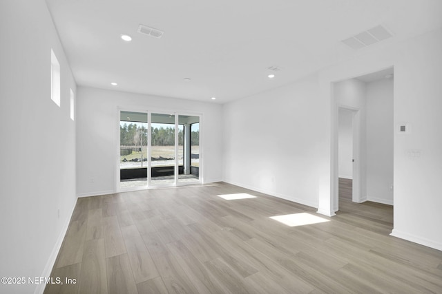 spare room with light wood-style floors, recessed lighting, and visible vents