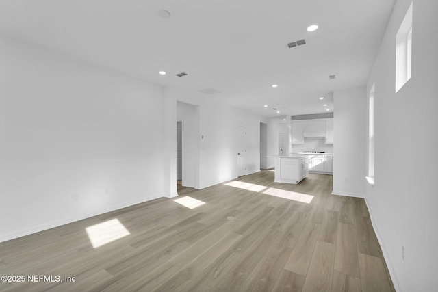 unfurnished living room with light wood-style flooring, visible vents, and recessed lighting