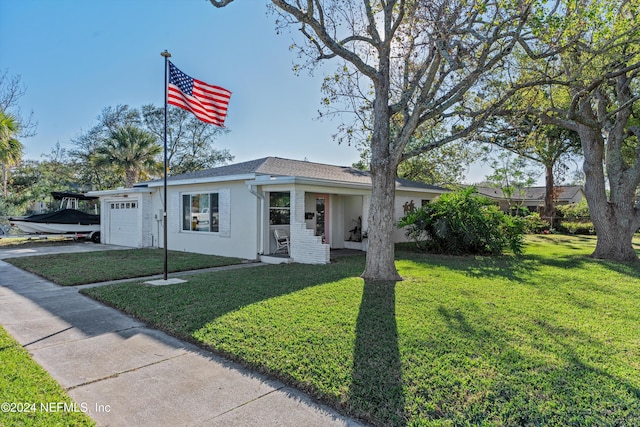 ranch-style house featuring a garage and a front lawn