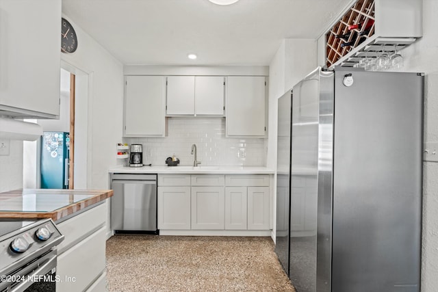 kitchen featuring decorative backsplash, stainless steel appliances, white cabinetry, and sink