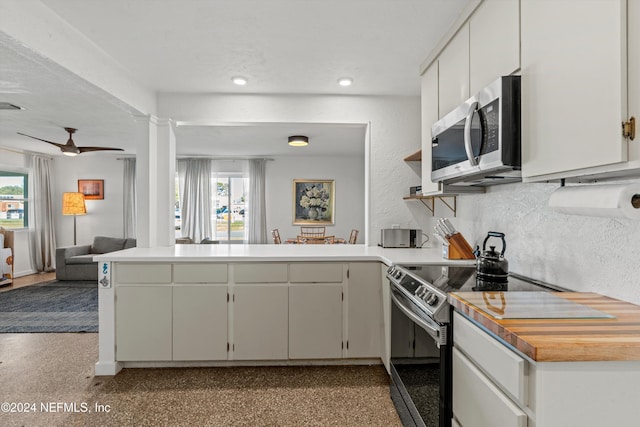 kitchen featuring kitchen peninsula, plenty of natural light, white cabinets, and stainless steel appliances