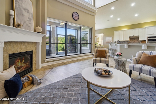 living room featuring hardwood / wood-style floors and a tiled fireplace