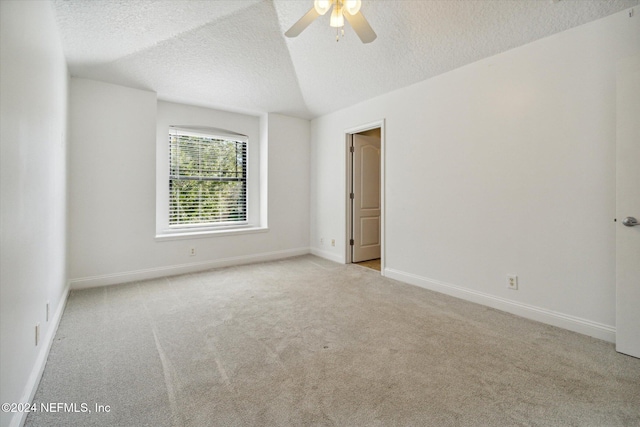 spare room featuring light carpet, ceiling fan, and a textured ceiling