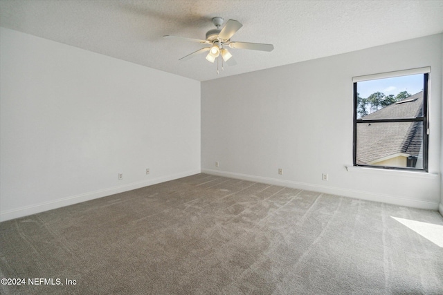 spare room with a textured ceiling, carpet floors, and ceiling fan