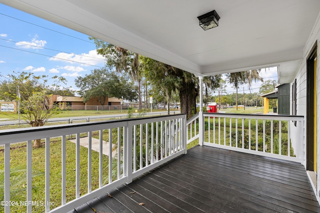 wooden deck featuring a lawn