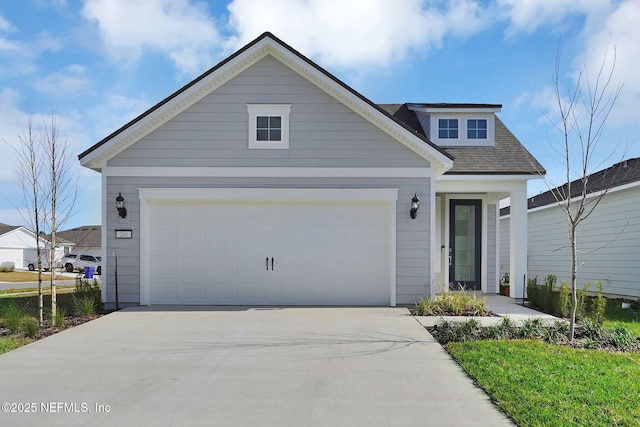 view of front facade with a garage, driveway, and a shingled roof