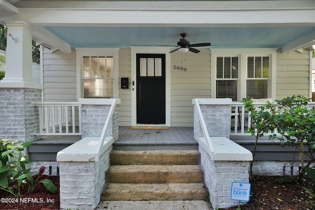 view of exterior entry featuring a porch and ceiling fan