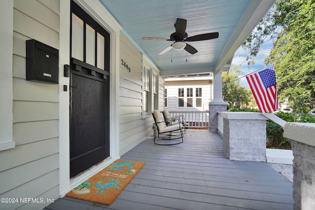 wooden deck with a porch and ceiling fan