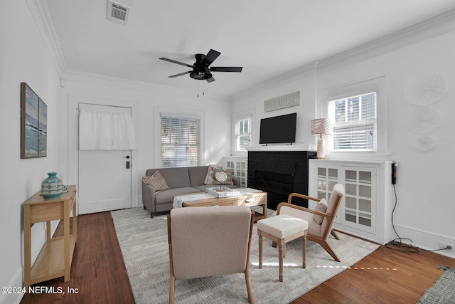 living room with hardwood / wood-style flooring, ceiling fan, a healthy amount of sunlight, and crown molding