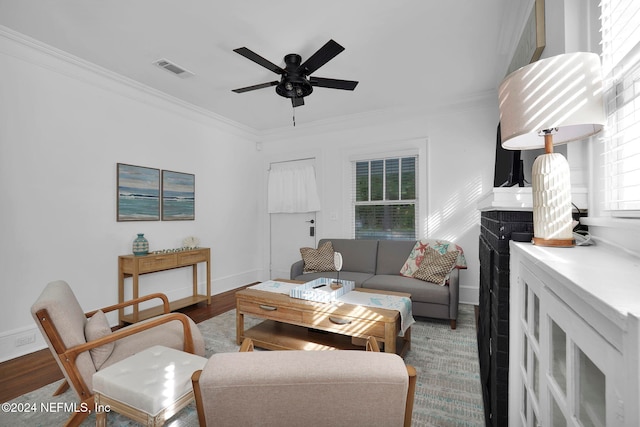 living room with ornamental molding, hardwood / wood-style flooring, and ceiling fan