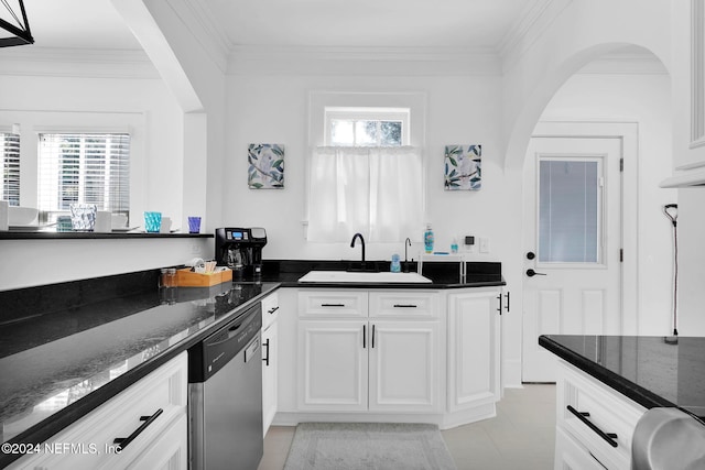 kitchen with dishwasher, a wealth of natural light, sink, and dark stone countertops