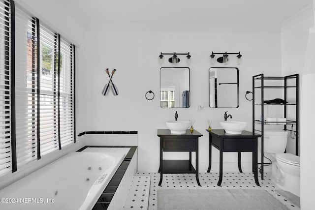 bathroom with toilet, vanity, crown molding, and a relaxing tiled tub