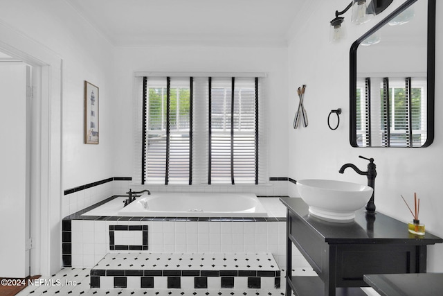 bathroom with a wealth of natural light, ornamental molding, and tiled tub