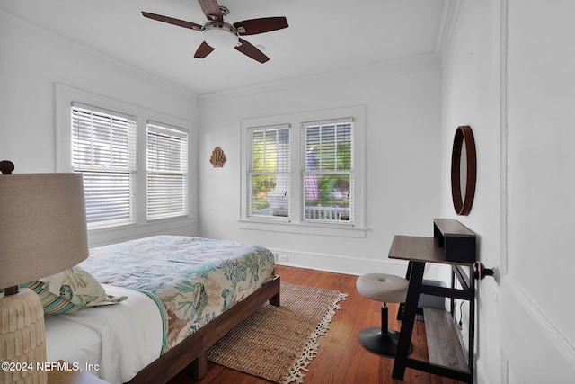 bedroom with ornamental molding, multiple windows, hardwood / wood-style floors, and ceiling fan