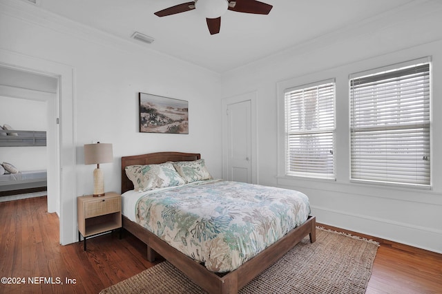 bedroom with dark hardwood / wood-style flooring, ceiling fan, and crown molding