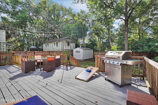 wooden deck with a storage shed and grilling area