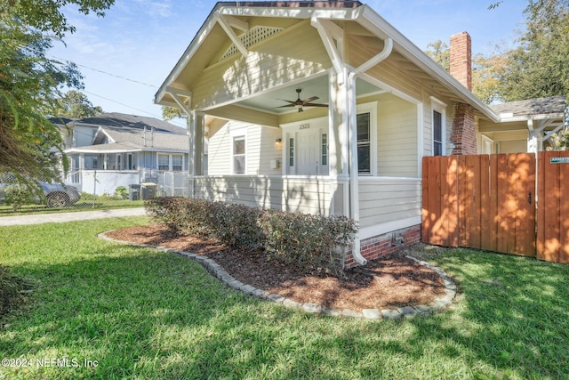 view of property exterior with ceiling fan, covered porch, and a yard