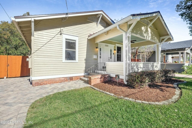 view of front of house featuring covered porch and a front yard