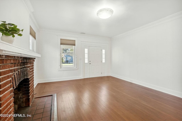 unfurnished living room with a fireplace, crown molding, and dark wood-type flooring