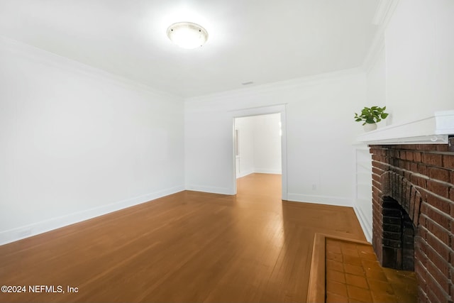 unfurnished living room with a fireplace, hardwood / wood-style floors, and crown molding