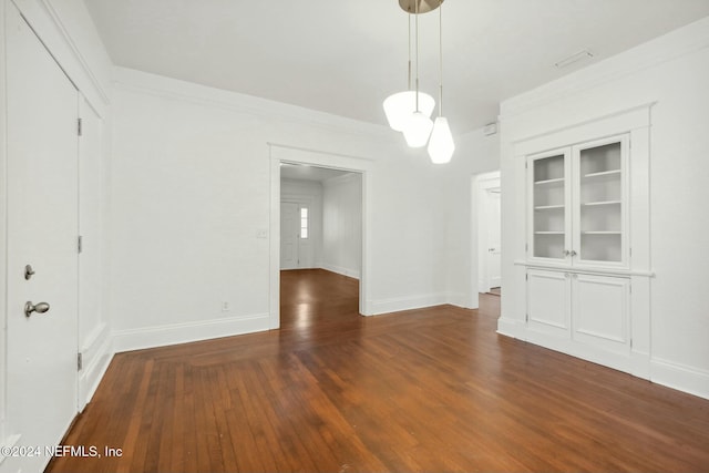 unfurnished dining area with dark hardwood / wood-style floors and crown molding