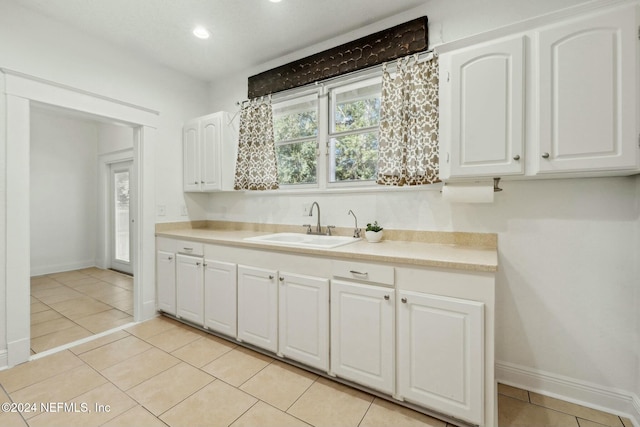 kitchen featuring white cabinetry, sink, and light tile patterned floors