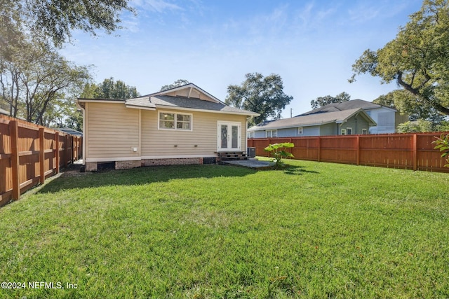 back of house featuring a lawn and french doors