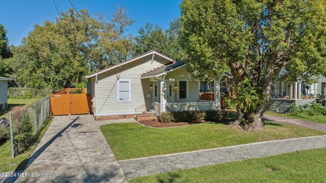 bungalow-style home with covered porch and a front yard