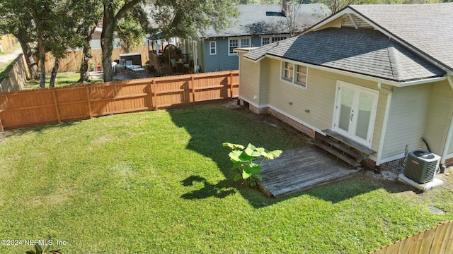 view of yard featuring french doors and cooling unit