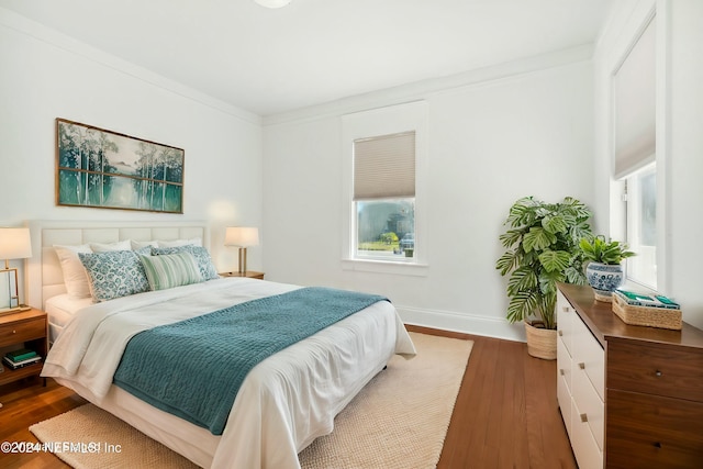 bedroom with crown molding and dark hardwood / wood-style flooring