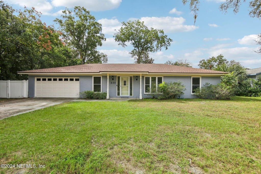 ranch-style house featuring a garage and a front yard