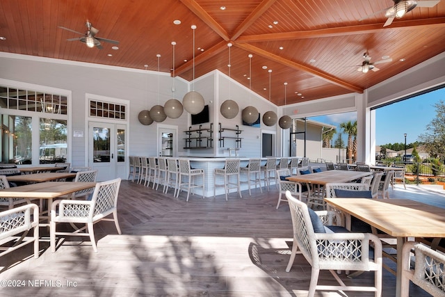 wooden terrace with ceiling fan, outdoor dining area, french doors, and outdoor wet bar