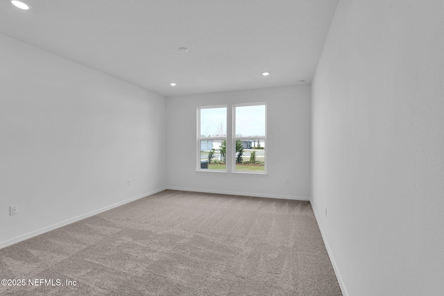 empty room featuring recessed lighting, carpet flooring, and baseboards