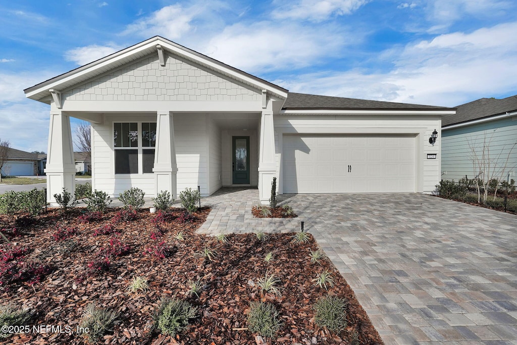 124 Creek Pebble Dr, Ponte Vedra, FL 32081 - view of front of home with a garage, roof with shingles, decorative driveway, and covered porch