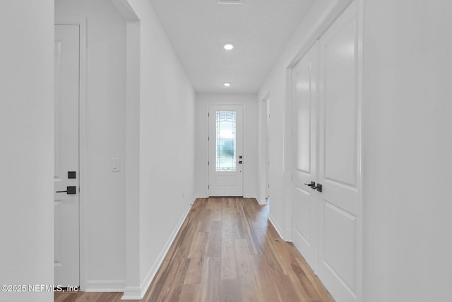 doorway to outside featuring light wood-style flooring and baseboards